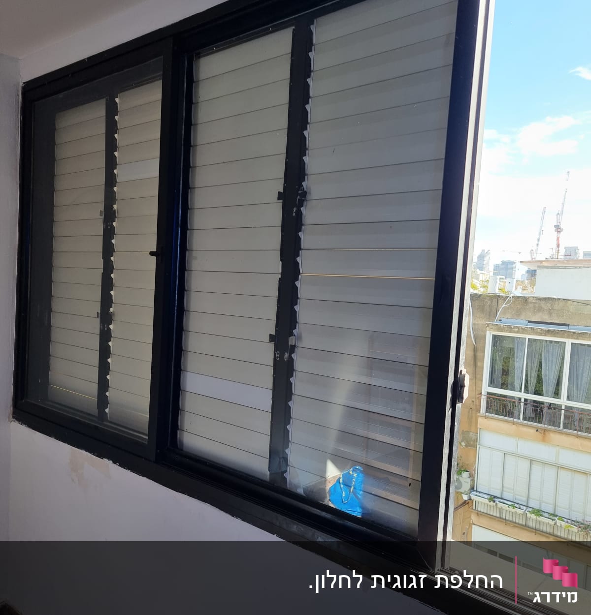 חלון זכוכית עם תריסים סגורים חלקית